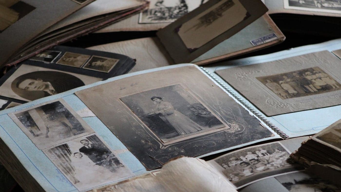 Photographies de famille anciennes et albums ouverts posés sur une table